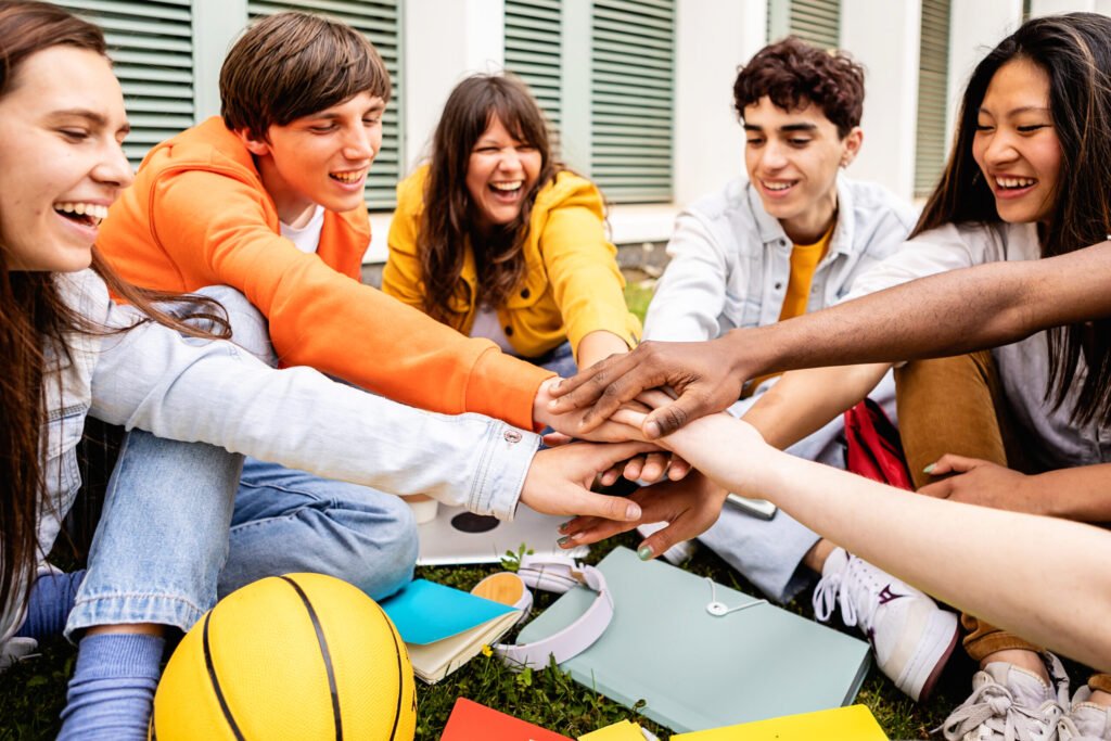 group-of-young-students-with-hands-in-together