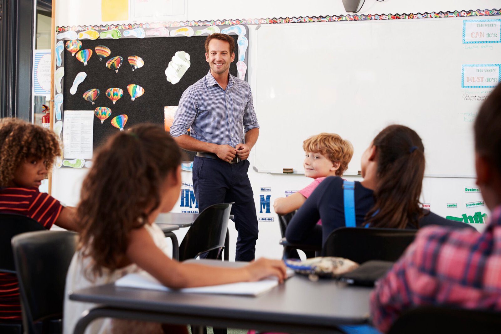 Smiling teacher at front of elementary school class